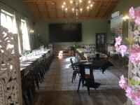 een eetkamer met tafels en stoelen en een groot scherm bij El Chozo in Fuentidueña