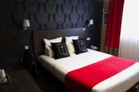 a hotel room with a bed with a red blanket at Hôtel Arcadia in Lannion