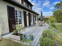 a wooden deck with a table and a umbrella at Maison Saint-Pair-sur-Mer, 5 pièces, 8 personnes - FR-1-361-56 in Saint-Pair-sur-Mer