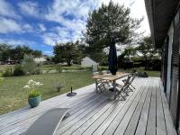 a wooden deck with a table and an umbrella at Maison Saint-Pair-sur-Mer, 5 pièces, 8 personnes - FR-1-361-56 in Saint-Pair-sur-Mer