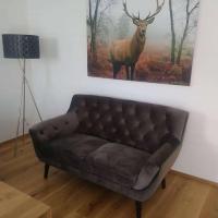 a couch in a living room with a picture of a deer at Ferienhaus Reiter Jochberg bei Kitzbühel in Jochberg