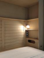 a bedroom with a bed and a light on the wall at Mes à Moi in Pezenas - Studio &amp; patio privatif - O Pitchoun in Pézenas