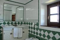 a bathroom with two sinks and a mirror at Hotel Tugasa Castillo de Castellar in Castellar de la Frontera