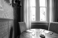 een eettafel met stoelen en een raam bij The Black Swan in Ravenstonedale