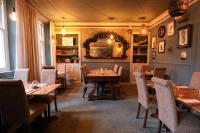 een restaurant met houten tafels en stoelen en een spiegel bij The Black Swan in Ravenstonedale