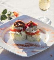 a sandwich on a plate with a glass of wine at Hotel Tugasa Convento San Francisco in Vejer de la Frontera