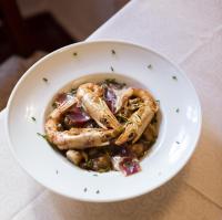 a bowl of food with shrimp and vegetables on a table at Hotel Tugasa Convento San Francisco in Vejer de la Frontera