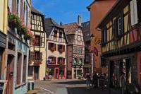 a city street with buildings and people walking down a street at Studio Marie-Rose in Ribeauvillé