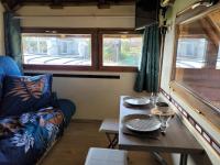 a living room with a table and a couch and a window at La paillote idyllique in Faverolles-sur-Cher