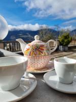 Una tetera y tazas en platos sobre una mesa. en nawu apartments & Restaurant, en Hermagor