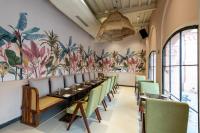 a dining room with a long table and green chairs at The Earth Amritsar, Trademark Collection by Wyndham in Amritsar