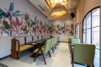 a dining room with a long table and green chairs at The Earth Amritsar, Trademark Collection by Wyndham in Amritsar