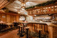 un bar en un restaurante con paredes y taburetes de madera en Hotel Restaurant Hexenalm, en Söll