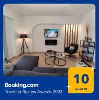 a living room with a couch and a tv at Grey Swan - Modern &amp; Stylish apartment with Private Parking in Volos