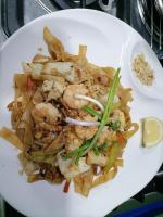 Un plato blanco de comida con camarones y fideos. en La Bella Swiss Inn, en San Vicente