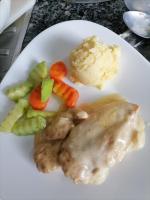 Un plato blanco con pollo y verduras y puré de patatas. en La Bella Swiss Inn, en San Vicente