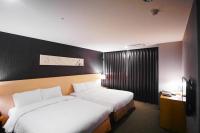 a hotel room with two beds and a window at Beacon Hotel in Taichung