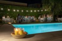 a bowl of yellow candles next to a swimming pool at Domìa Boutique Hotel e Cucina in Mondello