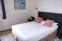 a bedroom with a large white bed with two pillows at Hôtel Arcadia in Lannion