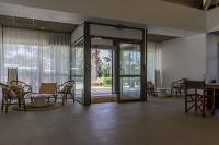 a lobby with a glass door with chairs and tables at Belambra Clubs Presqu&#39;île De Giens - Riviera Beach Club in Hyères