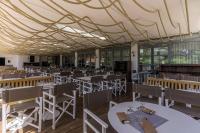 a dining hall with tables and chairs and a ceiling at Belambra Clubs Presqu&#39;île De Giens - Riviera Beach Club in Hyères