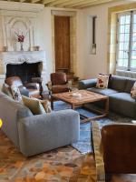 a living room with couches and a table and a fireplace at Jardin Meurin in Tabanac