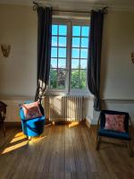 a living room with a large window and a blue chair at Jardin Meurin in Tabanac