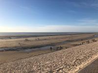 a group of people walking on a beach at Appartement A confortable et lumineux in Neufchâtel-Hardelot