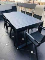 a black table and chairs on a balcony at Appartement A confortable et lumineux in Neufchâtel-Hardelot