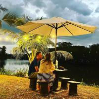 a man and a woman sitting at a table under an umbrella at Dangau Sala D'Kontena in Alor Setar
