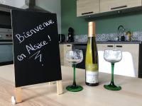 a bottle of wine and two glasses on a table at Appartement au cœur du Val d&#39;Argent in Sainte-Croix-aux-Mines