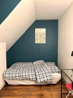a bed in a bedroom with a blue wall at [New] Eiffel tower view studio &#47; Paris Étoile in Paris