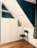 a room with white cabinets and a black chair at [New] Eiffel tower view studio &#47; Paris Étoile in Paris