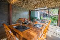 a dining room with a long wooden table and chairs at Malabar Pool Villa Phuket in Phuket Town