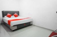 a bedroom with a bed with red and white pillows at Hotel O Pondok Cahaya in Makassar