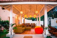 un patio con sofá y sillas bajo un pabellón en Tree of Life Resort, en Bentota
