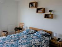 a bedroom with a bed with a blue and white comforter at Appartement Perros-Guirec, 2 pièces, 4 personnes - FR-1-368-293 in Perros-Guirec