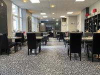 a dining room with tables and chairs in a restaurant at Hôtel Restaurant de l'Ecu in Jonzac
