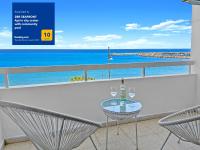 una mesa de cristal con 2 sillas en un balcón con vistas al océano en 2BR SEAFRONT Apt in city center with community pool, en Lárnaca