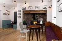 a living room with a table and chairs and a fireplace at Tafarn Yr Heliwr in Nefyn