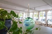 ディオにあるMöckelsnäs Herrgårdの植物のテーブルに座るガラス花瓶