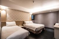 a hotel room with two beds and a kitchen at Global Traveler Hotel in Kaohsiung