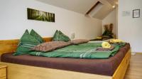 a bed with green and brown pillows on it at Gasthof zum Postwirt in Predlitz