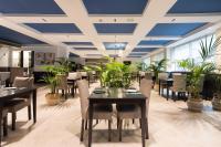 a dining room with tables and chairs and plants at Hotel Colon Rambla in Santa Cruz de Tenerife