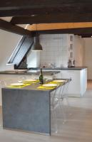 a kitchen with a counter with chairs and a sink at Bretzel &amp; Raisin - Hypercentre de Colmar in Colmar