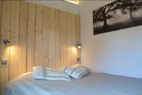 a bed with two pillows in a room with wooden walls at Bretzel &amp; Raisin - Hypercentre de Colmar in Colmar