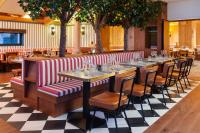 um restaurante com mesas e cadeiras num piso de xadrez em Ours Blanc Hotel & Spa em Les Menuires