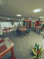 a dining room with tables and chairs and a table at Sollaris Ecopousada in Japaratinga