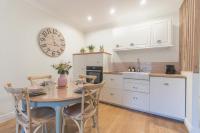 a kitchen with a table and chairs and a clock at T3 rénové 10min gare Part dieu - Quartier typique in Lyon