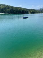 a sail boat in the middle of a large lake at Ferienwohnung am Walchensee in Walchensee